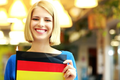 Cheerful blonde girl holding flag of Germani