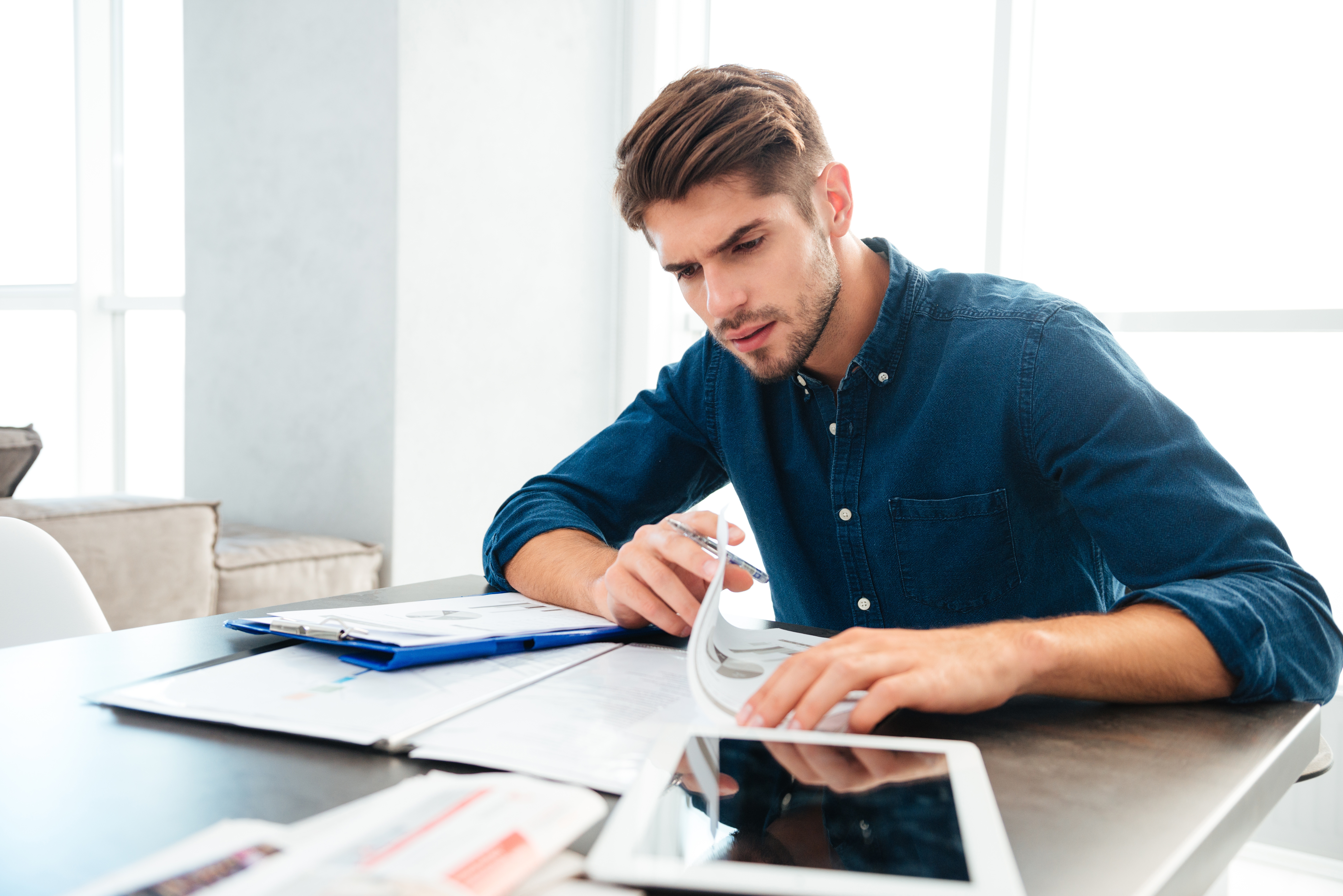 busy-young-man-sitting-at-home-and-thinking-about-PZK7Y33